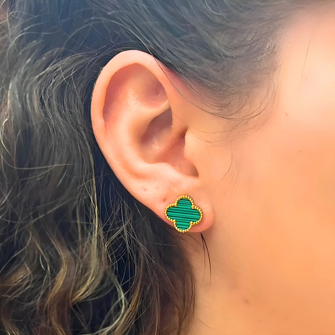 Žena nosi Van Cleef‑stil naušnice u obliku djeteline, minimalistički styling